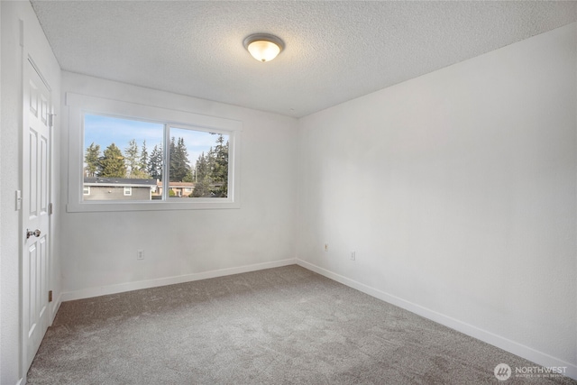 carpeted empty room featuring baseboards and a textured ceiling