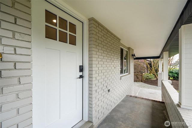 property entrance with brick siding and covered porch