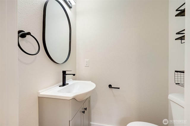 half bathroom featuring toilet and vanity