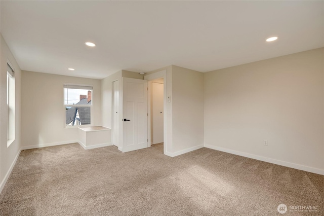 carpeted empty room featuring recessed lighting and baseboards