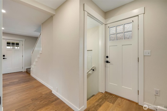 entryway with stairway, light wood-type flooring, and baseboards