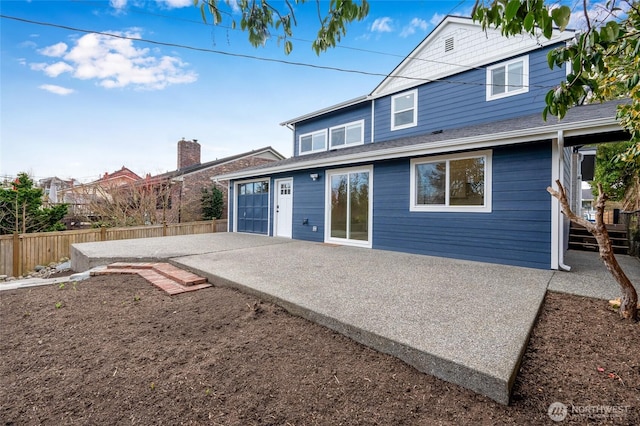 rear view of house with a patio, a fenced backyard, and driveway