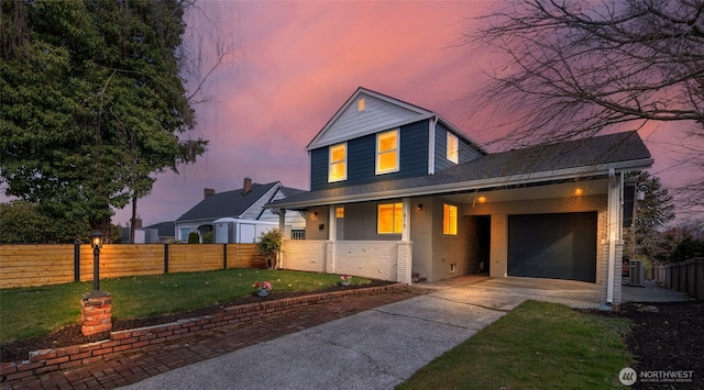 view of front of property featuring fence, concrete driveway, a garage, a lawn, and brick siding