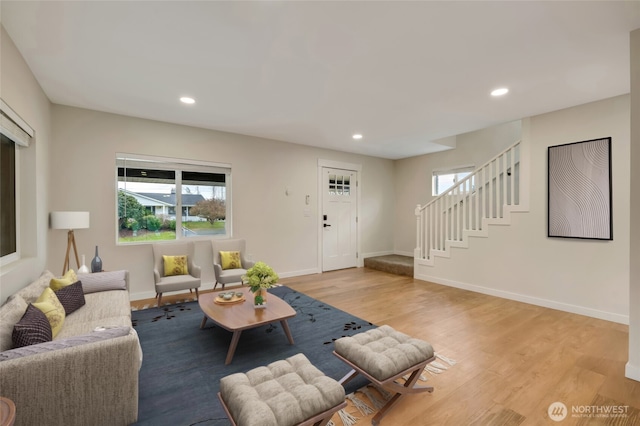 living area with recessed lighting, light wood-type flooring, stairs, and baseboards