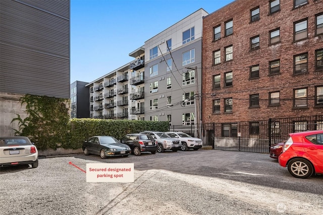 view of property with uncovered parking and fence