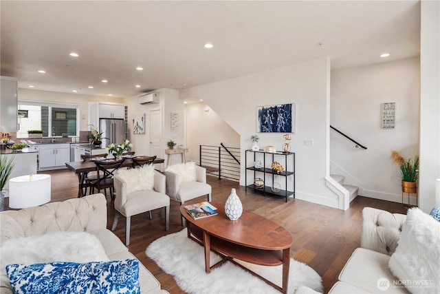 living room featuring dark wood finished floors, stairs, recessed lighting, and a wall mounted air conditioner