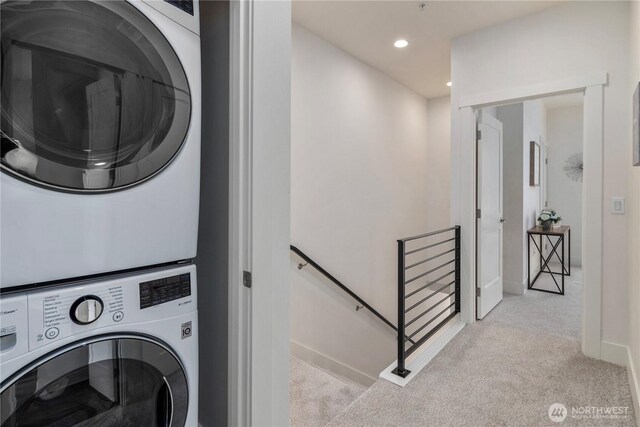 laundry area featuring recessed lighting, light colored carpet, laundry area, and stacked washing maching and dryer