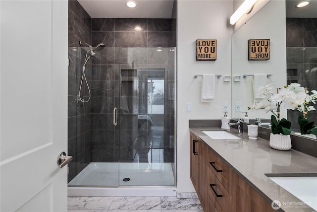 bathroom with double vanity, recessed lighting, a stall shower, a sink, and marble finish floor