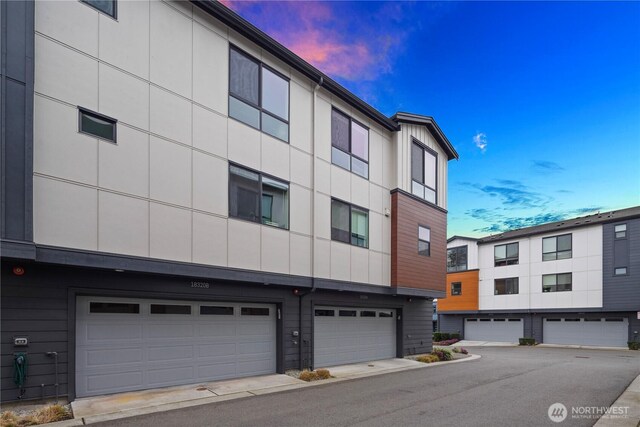 property at dusk featuring an attached garage