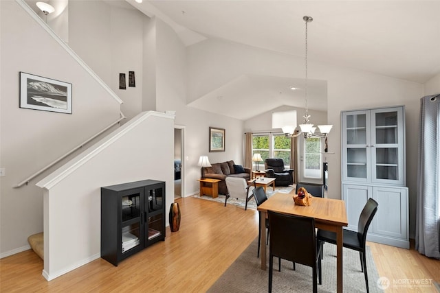 dining room with stairway, baseboards, high vaulted ceiling, an inviting chandelier, and light wood-type flooring