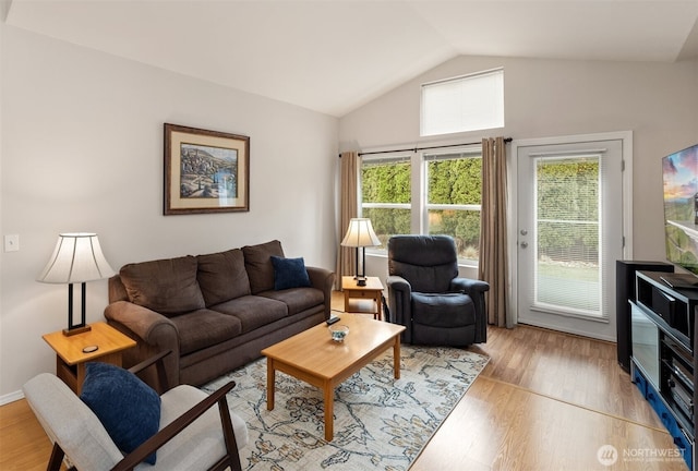 living area featuring lofted ceiling and light wood finished floors