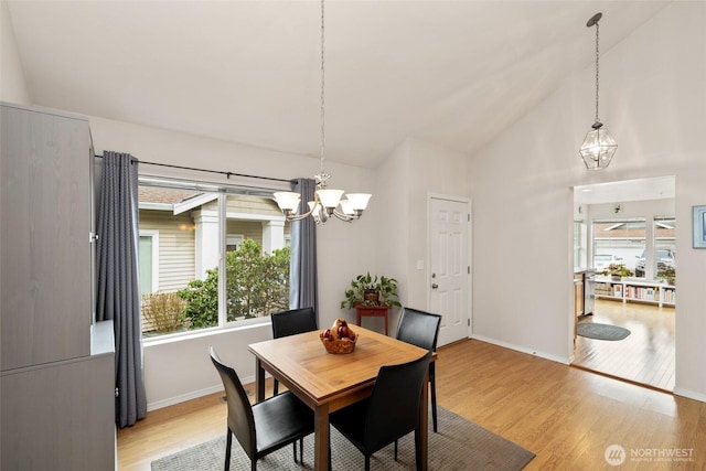 dining room featuring light wood-type flooring, baseboards, and a chandelier