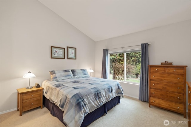 bedroom with vaulted ceiling, light colored carpet, and baseboards