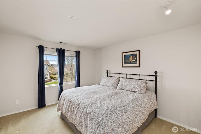 bedroom with light colored carpet and baseboards