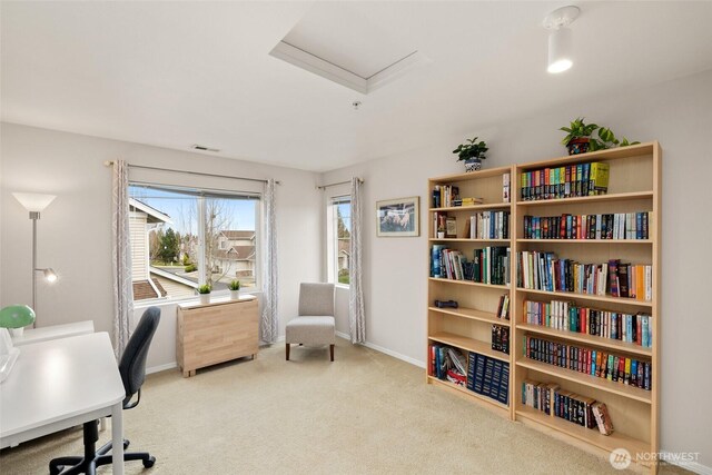 carpeted office with baseboards and attic access