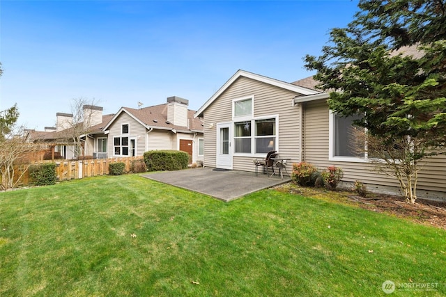 rear view of house with a patio area, a lawn, and fence