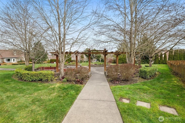 view of home's community with fence, a lawn, and a pergola