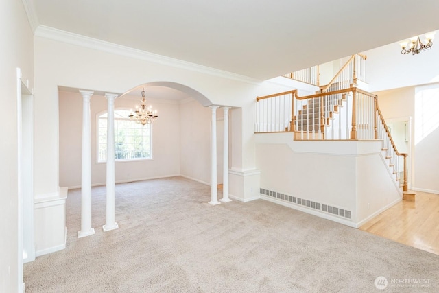 interior space featuring arched walkways, carpet floors, stairs, and crown molding