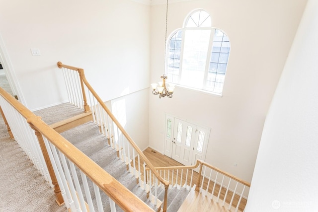 staircase featuring a notable chandelier