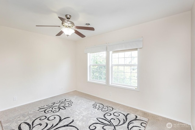 empty room featuring a ceiling fan and light carpet