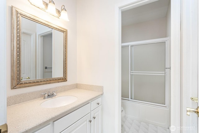 full bathroom with enclosed tub / shower combo, toilet, and vanity