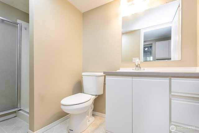 full bathroom with tile patterned floors, toilet, a shower stall, baseboards, and vanity