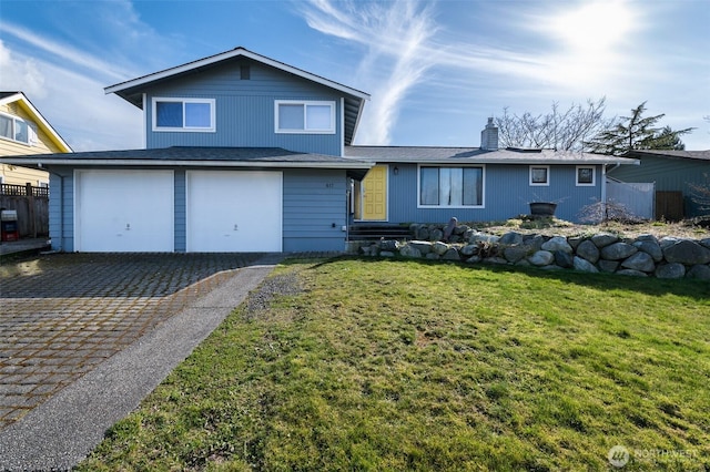 view of front of house with decorative driveway, a front yard, and fence