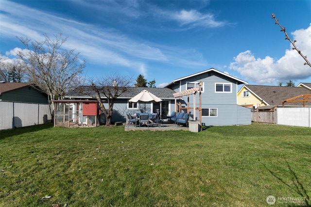 rear view of property with fence, exterior structure, an outdoor structure, a yard, and a patio