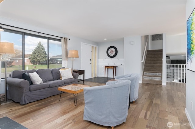 living area with stairs, recessed lighting, and light wood-style floors