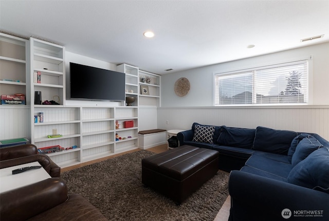 living room featuring recessed lighting, visible vents, and a wainscoted wall