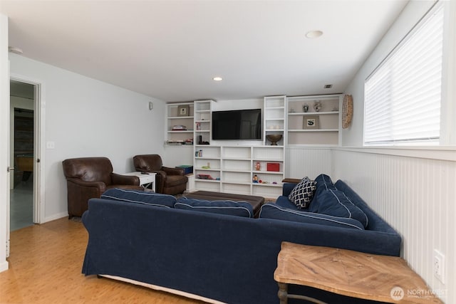 living area with light wood-style flooring and recessed lighting