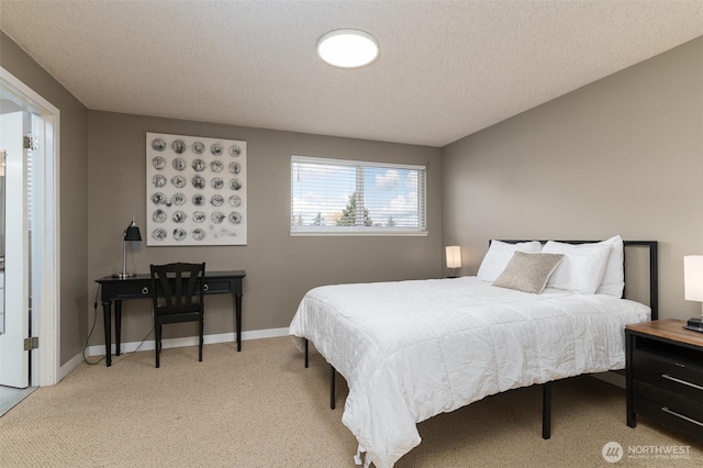 bedroom featuring light colored carpet, baseboards, and a textured ceiling