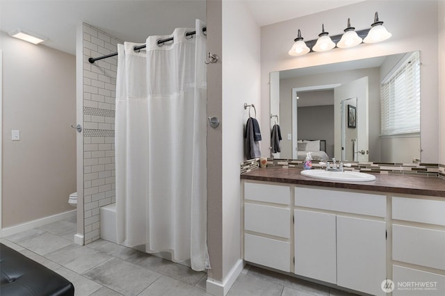 full bathroom featuring tile patterned floors, shower / tub combo with curtain, toilet, baseboards, and vanity