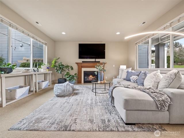 living room featuring visible vents, recessed lighting, and a glass covered fireplace