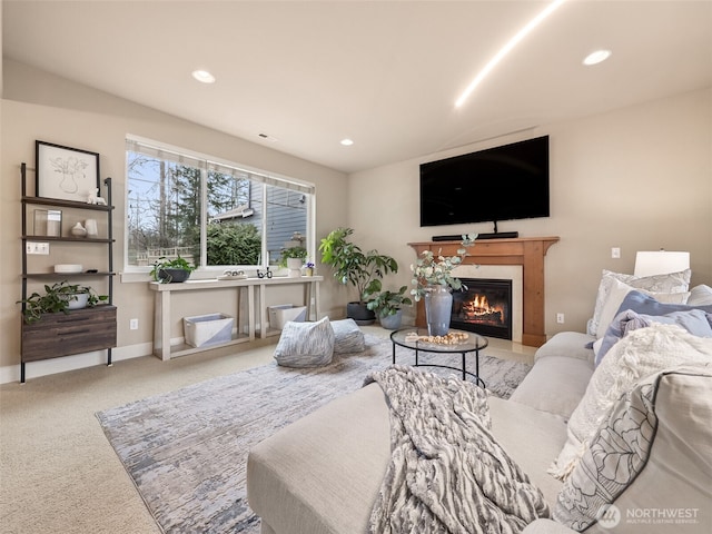 living room with recessed lighting, baseboards, a glass covered fireplace, and carpet flooring