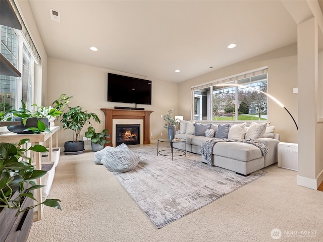 living area with visible vents, carpet floors, baseboards, recessed lighting, and a glass covered fireplace