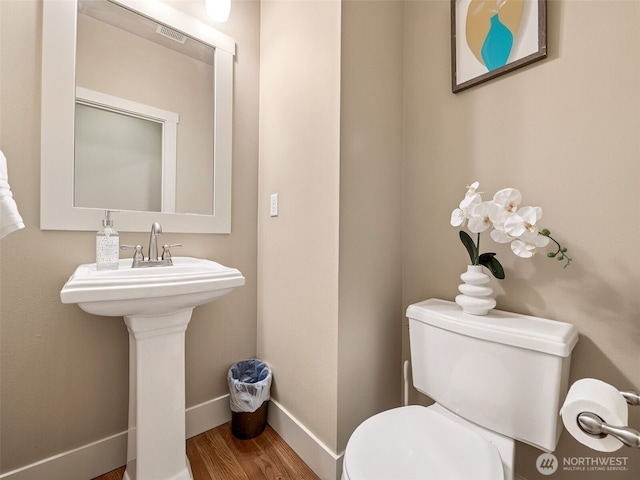 bathroom featuring wood finished floors, visible vents, baseboards, a sink, and toilet