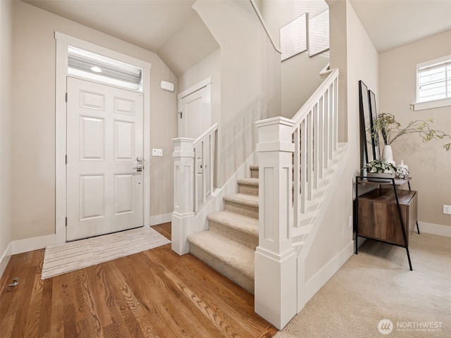 foyer featuring stairway, wood finished floors, and baseboards