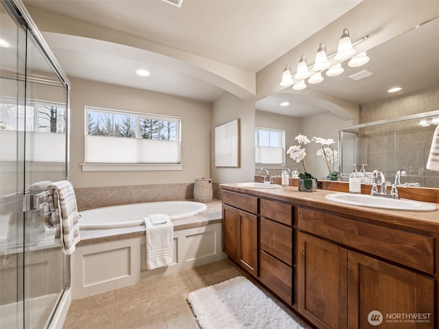 bathroom featuring a sink, a garden tub, a stall shower, and tile patterned flooring