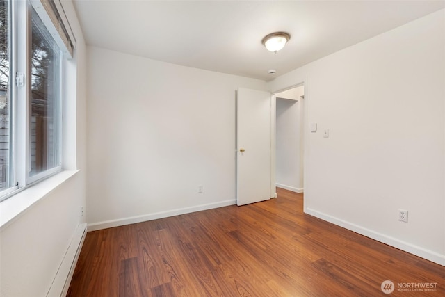 empty room featuring baseboards and wood finished floors