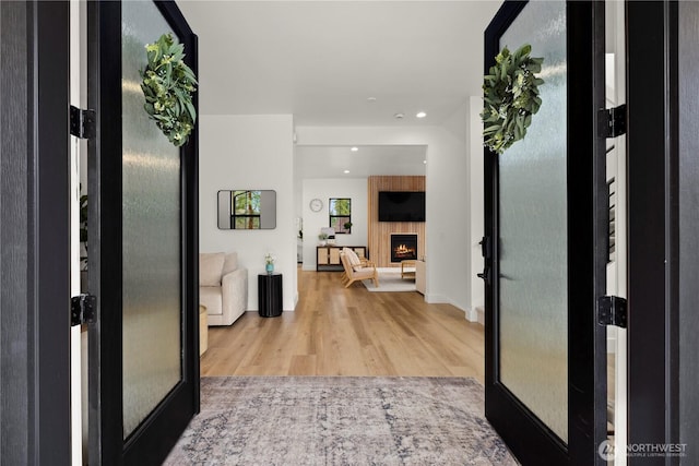 hallway featuring recessed lighting, french doors, and light wood-type flooring