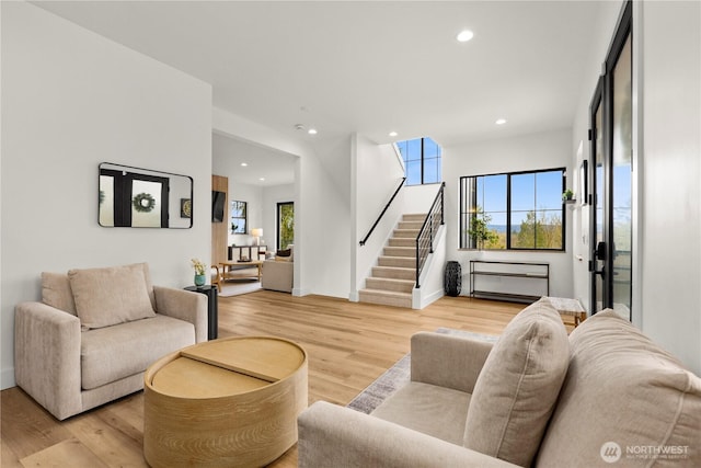 living room with stairway, recessed lighting, and light wood-style floors