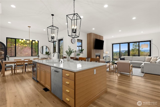 kitchen with a sink, light wood-type flooring, dishwasher, and recessed lighting