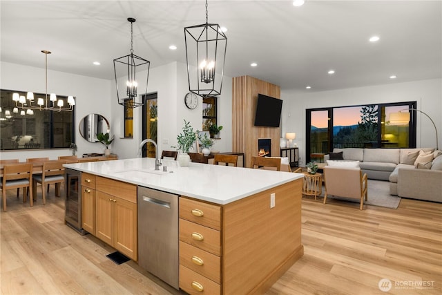 kitchen featuring a sink, stainless steel dishwasher, beverage cooler, and recessed lighting