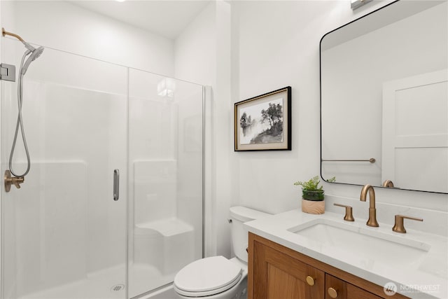 bathroom with vanity, toilet, and a stall shower