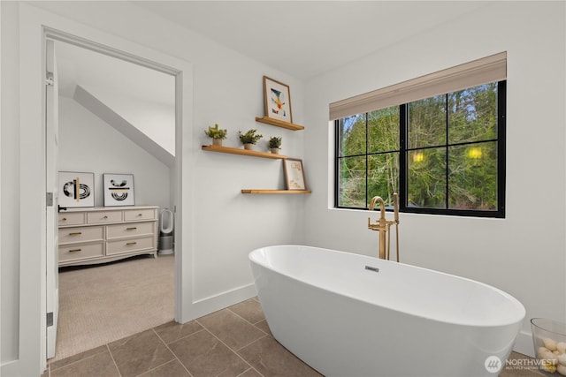 full bath featuring a freestanding tub and tile patterned flooring