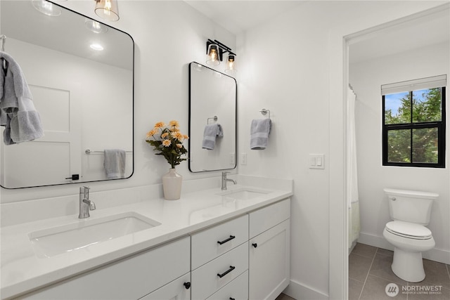 full bath with a sink, toilet, double vanity, and tile patterned flooring