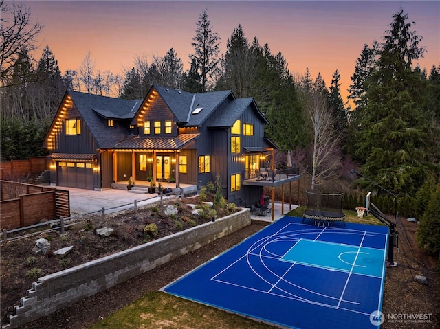 view of basketball court with basketball hoop and fence