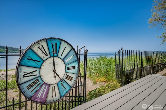 surrounding community with a water view, an outdoor structure, and fence