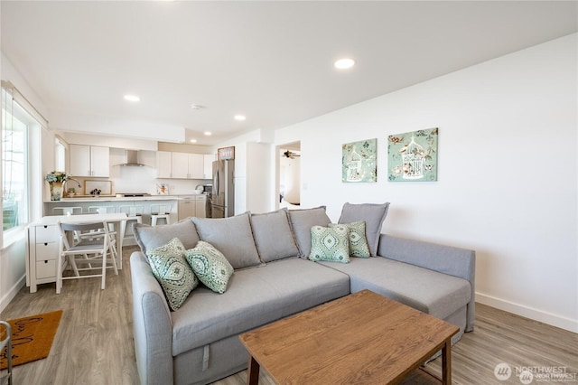 living area with recessed lighting, baseboards, and light wood-style floors